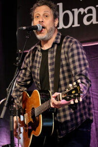 Reto Burrell (vocals, acoustic guitar, harmonica, kazoo, stompboard)